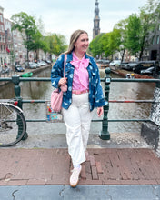 Load image into Gallery viewer, Girl standing in front of a canal wearing a denim polka dot jacket with pink bow top and white barrel jeans
