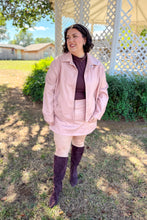 Load image into Gallery viewer, Girl wearing a faux pink leather jacket and skort set with brown undershirt and brown knee high boots standing in front of a gazebo. 
