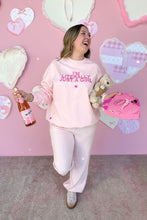Load image into Gallery viewer, Girl in a pink sweatshirt that says I’m Literally Just a Girl and pink knit pants standing in front of a pink heart wall holding chocolates, a bear, and sparkling rose juice
