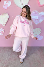 Load image into Gallery viewer, Girl in a pink sweatshirt that says I’m Literally Just a Girl and pink knit pants standing in front of a pink heart wall
