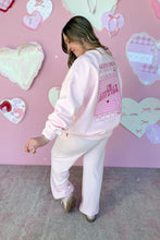 Load image into Gallery viewer, Girl in a pink sweatshirt that says I’m Literally Just a Girl and pink knit pants standing in front of a pink heart wall Back view
