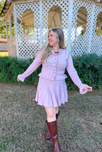 Load image into Gallery viewer, Girl wearing a pink ruffle cardigan skirt set with brown knee high boots standing in front of a gazebo. 
