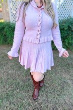 Load image into Gallery viewer, Girl wearing a pink ruffle cardigan skirt set with brown knee high boots standing in front of a gazebo. 
