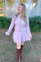 Load image into Gallery viewer, Girl wearing a pink ruffle cardigan skirt set with brown knee high boots standing in front of a gazebo. 
