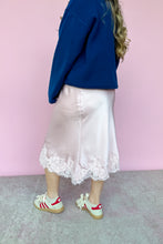 Load image into Gallery viewer, Person wearing a blue sweater and white lace skirt against a pink wall.
