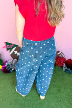 Load image into Gallery viewer, Woman wearing polkadot denim barrel jeans with a red top standing in front of a pink backdrop.
