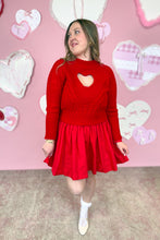Load image into Gallery viewer, Woman wearing a red dress with a red sweater with a heart design in front of a pink wall with heart decorations.
