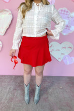 Load image into Gallery viewer, Person wearing a white blouse, red skirt, and silver boots against a pink wall with heart decorations.

